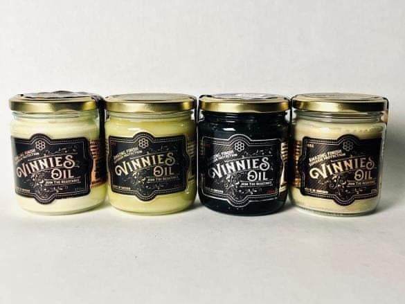 Four jars of 'Vinnies Oil' on a white background